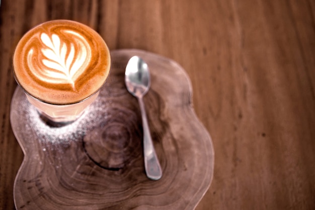 Kop warme cappucino is op houten tafel achtergrond het is latte art op de top