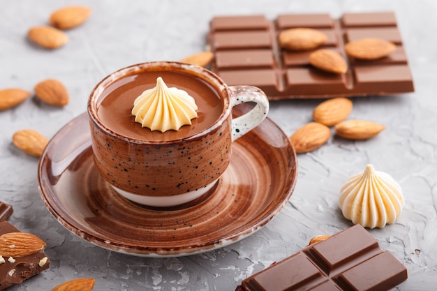 Kop warme chocolademelk en stukjes melkchocolade met amandelen