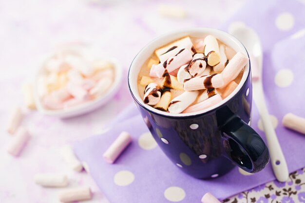 Kop warme chocolademelk of chocolade met marshmallow op een lichte tafel.