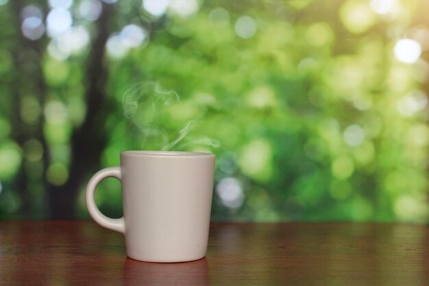 Kop warme drank met groene bokehachtergrond