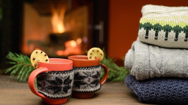 Kop warme drank voor warme open haard Stapel gezellige gebreide truien