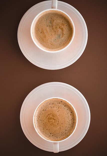 Kop warme koffie als ontbijtdrank flatlay kopjes op bruine achtergrond