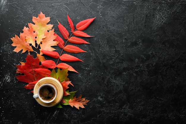 Kop warme koffie en gekleurde herfstbladeren plat op de oude achtergrond Bovenaanzicht Vrije ruimte voor uw tekst