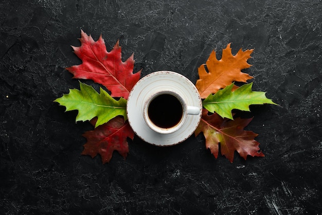 Kop warme koffie en gekleurde herfstbladeren plat op de oude achtergrond Bovenaanzicht Vrije ruimte voor uw tekst