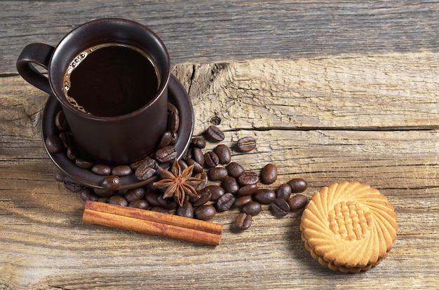 Kop warme koffie en koekje op oude houten tafel