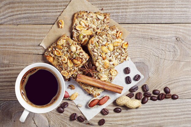 Kop warme koffie en koekjes met noten op oude houten tafel, van bovenaf bekijken