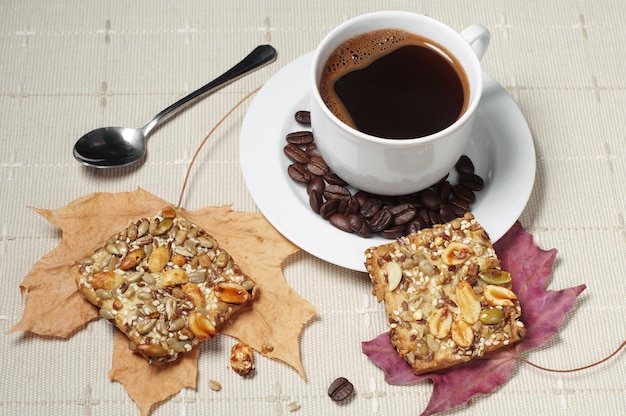 Kop warme koffie en koekjes met noten op tafel gedekt tafelkleed