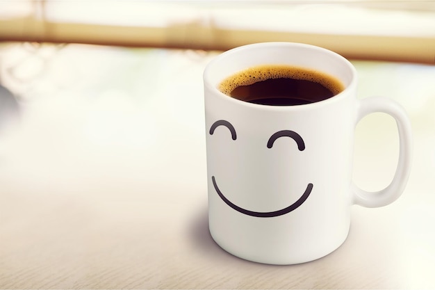 Kop warme koffie met een glimlach op een lichte achtergrond