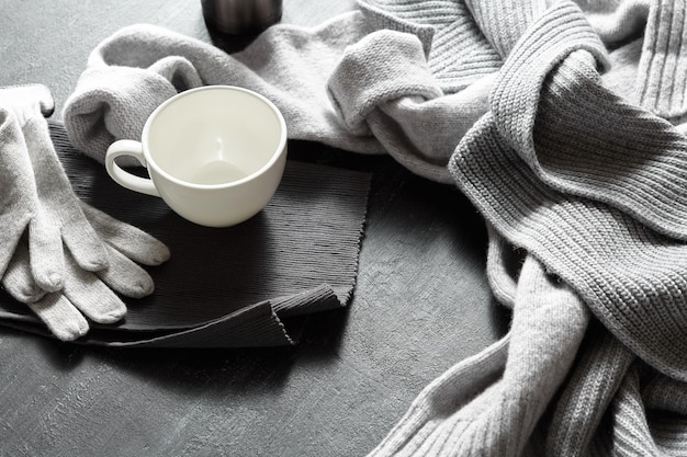 Kop warme koffie op een zwarte tafel met warme trui