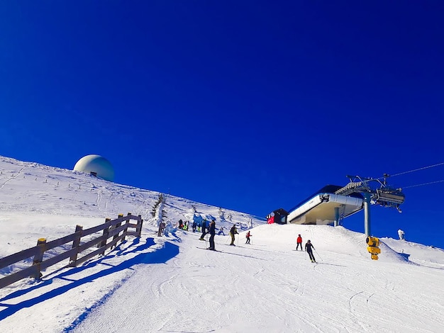 Kopaonik 세르비아 2019년 3월 15일 사람들은 화창한 날 산 꼭대기에서 스키를 즐깁니다.