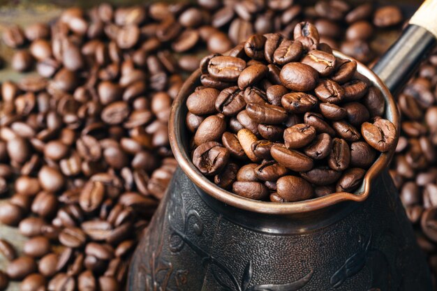 Koperen koffiepot voor de bereiding van koffie op verspreide koffiebonen