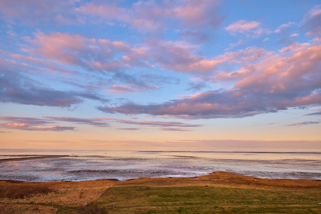 Kopieer de ruimte strand en zeezicht bij zonsondergang met kalme serene en vredige oceaan met zonsopganghemel Ontspannend tropisch en afgelegen zeegezicht op privé kustzomereiland met golven gras en copyspace