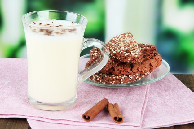 Kopje advocaat met kaneel en koekjes op tafel op lichte achtergrond