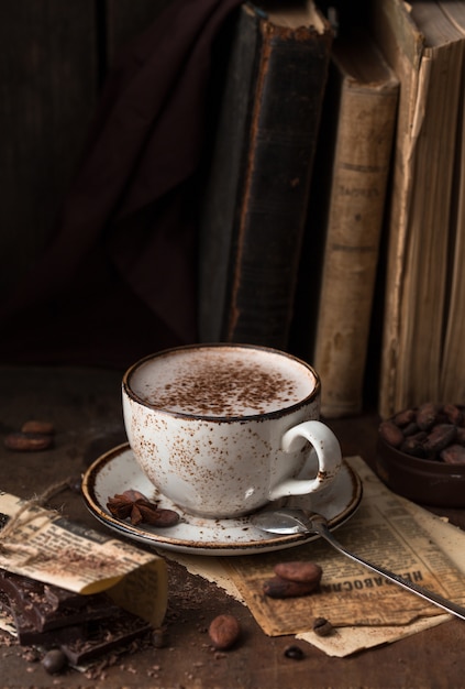 Kopje aromatische cacao op oude tafel met cacaobonen