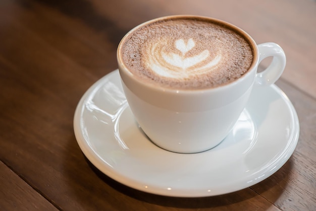 Kopje art latte of cappuccino koffie op houten tafel