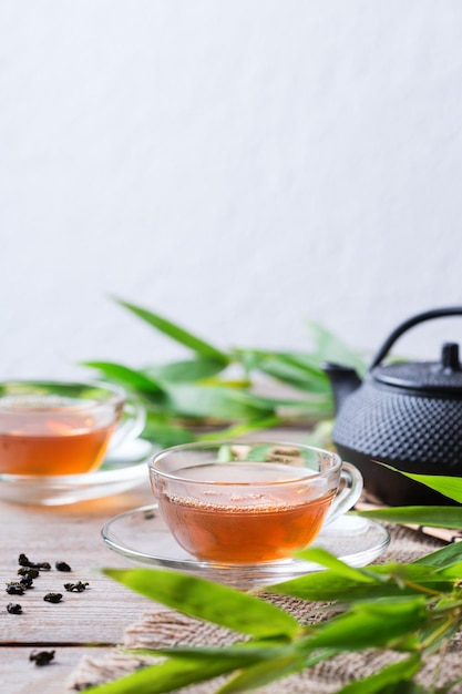 Kopje biologische hete groene thee op een houten tafel met bamboebladeren Kopieer de ruimteachtergrond