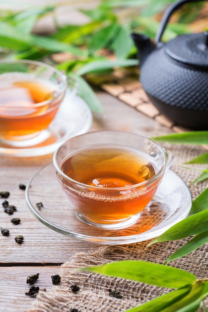 Kopje biologische warme groene thee op een houten tafel met bamboebladeren