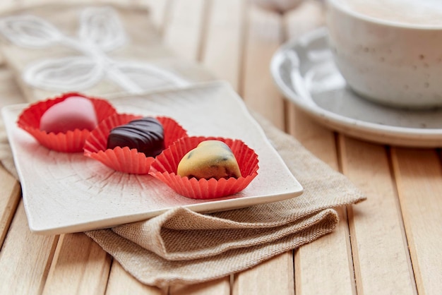 Kopje cappuccino en chocoladesnoepjesharten Esthetische koffietijd buiten Romantische date Valentijnsdag