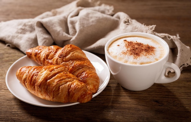 Kopje cappuccino koffie en croissants