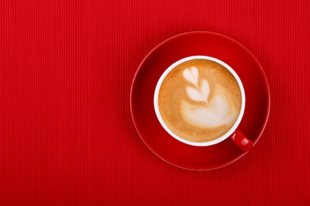 Kopje cappuccino koffie op rode schotel