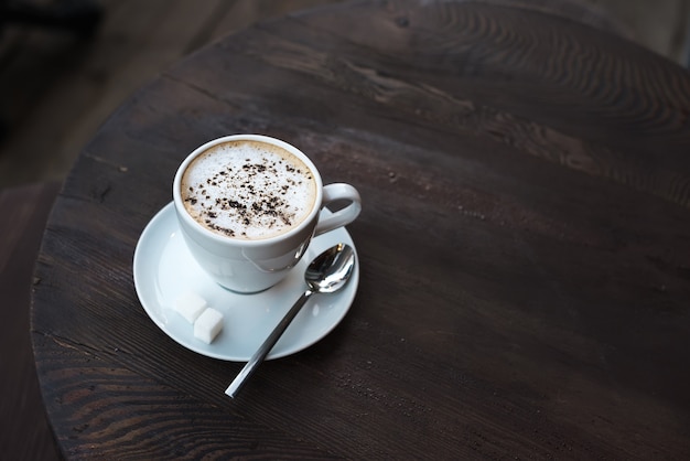 Kopje cappuccino op oude donkere houten tafel