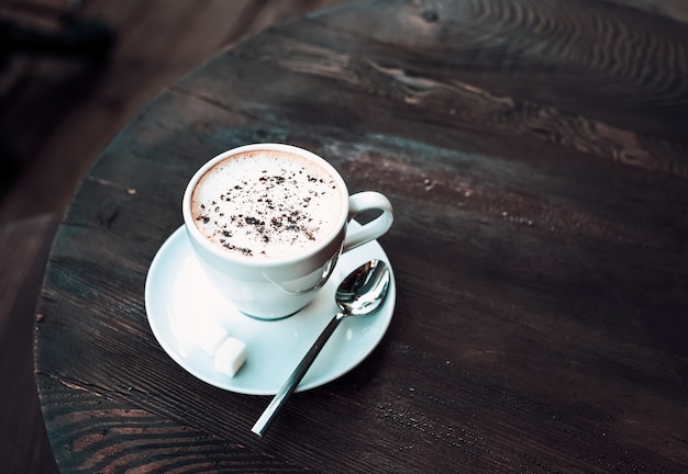 Kopje cappuccino op oude donkere houten tafel