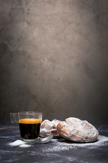 Kopje espresso met twee chocoladecroissants en poedersuiker