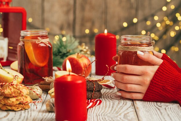 Kopje glühwein in handen van de vrouw op houten tafel