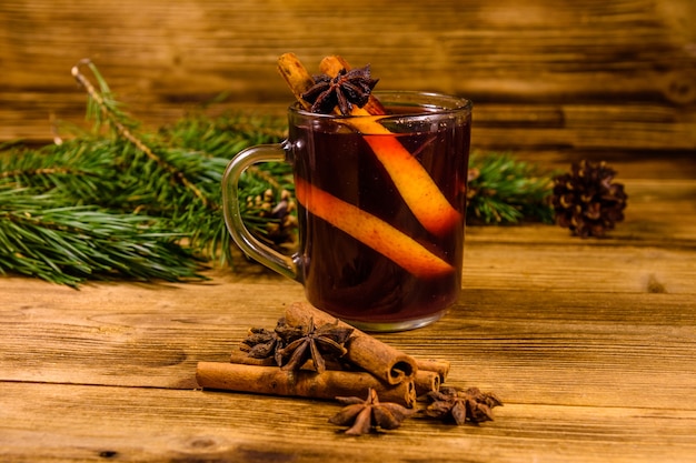 Kopje glühwein met kaneel en sparren takken op rustieke houten tafel