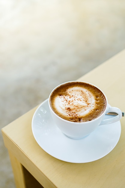 kopje hete latte koffie met mooie melkschuim latte art textuur op houten tafel.