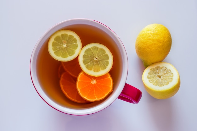 Foto kopje hete thee met citroen voor het maken van een warm drankje voor griep, coronavirus en verkoudheid.
