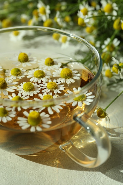 Kopje kamillethee op witte getextureerde tafel