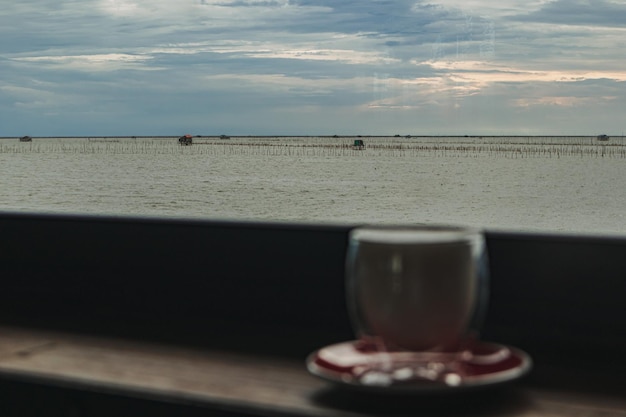 Kopje koffie aan de bar met avondzicht op zee