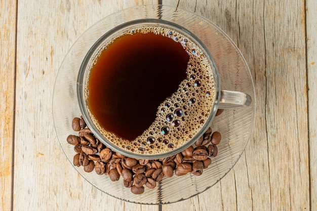 kopje koffie bovenaanzicht, met koffiebonen over houten tafel