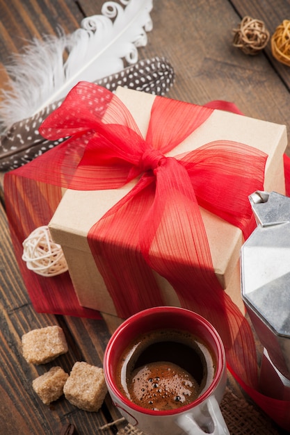 Kopje koffie, cadeau met rood lint, bruine suiker