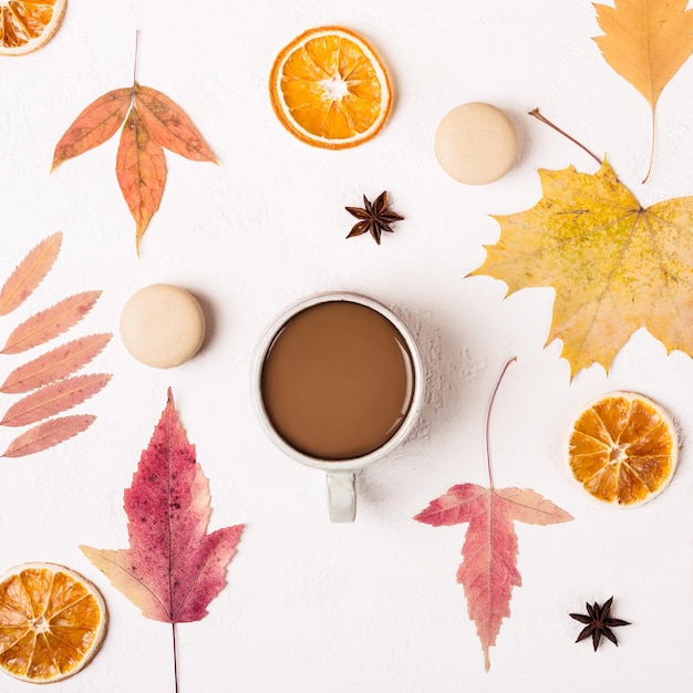 Kopje koffie en bitterkoekjes koekjes op witte tafel met herfstbladeren patroon