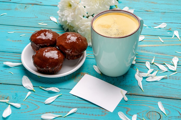 Kopje koffie en bloemen op lichte houten tafel