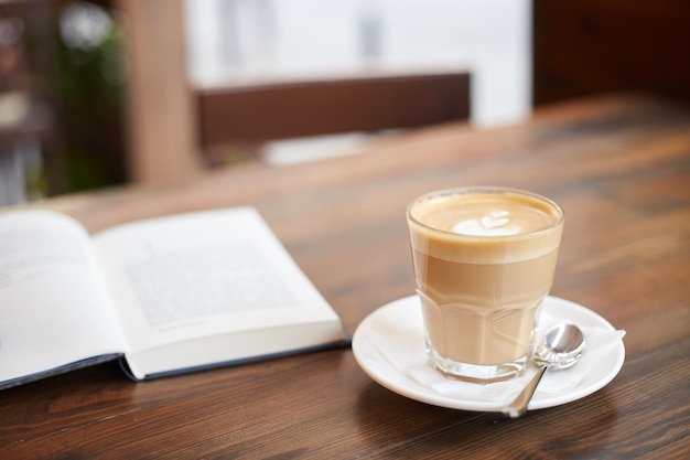 Kopje koffie en boek op tafel in straatcafé