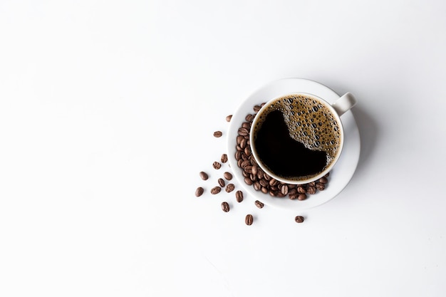 Kopje koffie en bonen op witte tafel achtergrond bovenaanzicht