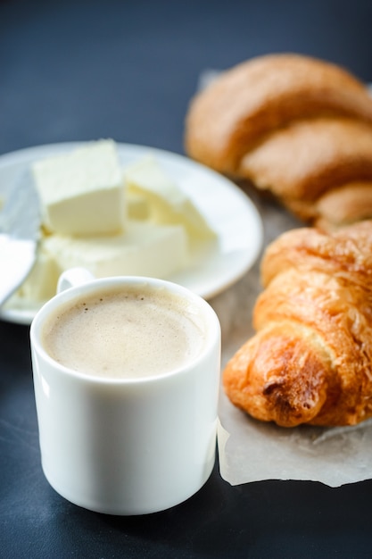 Kopje koffie en croissants met boter