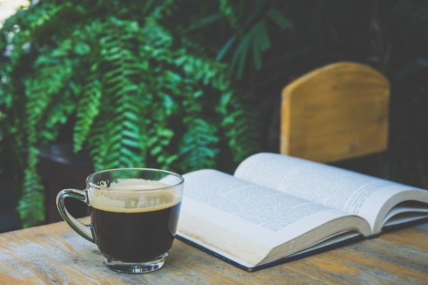 Kopje koffie en een boek op een houten tafel