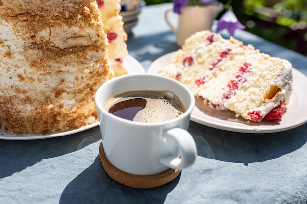 Kopje koffie en een stuk zelfgemaakte frambozenbiscuit in de tuin op een heldere zonnige mor