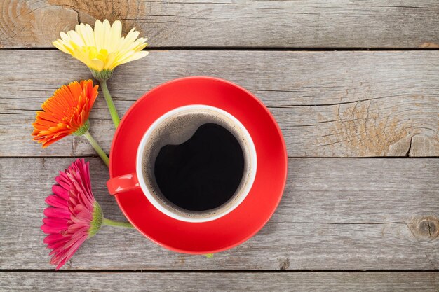 Kopje koffie en gerbera bloemen