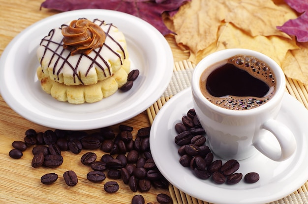 Kopje koffie en kleine cake op tafel