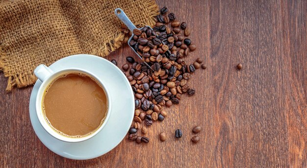 Kopje koffie en koffiebonen in een zak op bruine bovenaanzicht als achtergrond