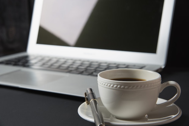 Kopje koffie en laptop op de tafel