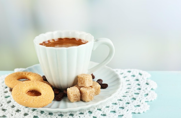 Kopje koffie en lekkere koekjes op een houten kleurentafel op lichte achtergrond