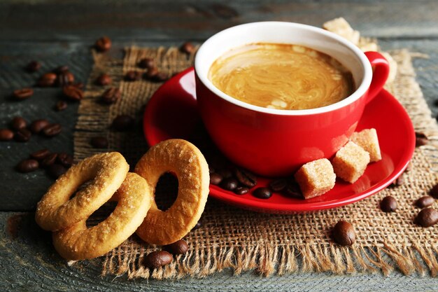 Kopje koffie en lekkere koekjes op jute servet op houten achtergrond