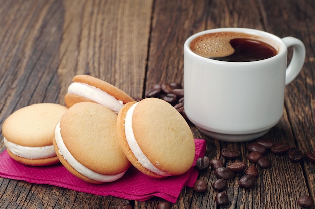 Kopje koffie en marshmallow cookies op houten tafel