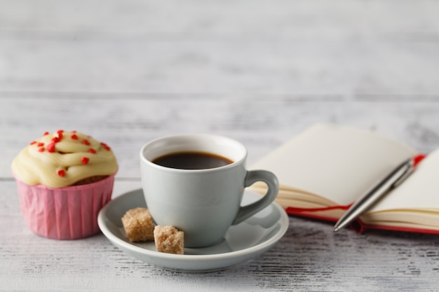 Kopje koffie en muffin op kantoor tafel in het begin van de werkdag